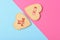 Valentines Day Concept: Two Heart shaped sugar cookies one on pink one on blue with Be Mine and XOXO written in icing