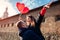 Valentines day couple. Man holding his girlfriend raising arms with balloons on city street. People having fun