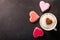 Valentines day.  Cup of cappuccino coffee with drawn heart and colorful heart shaped cookies, top view