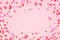 Valentines Day frame with candy heart sprinkles over a pink background with copy space