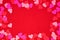 Valentines Day frame of heart confetti over a red background with copy space