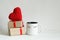 Valentines day gift boxes, toy heart and coffee cup with cutest funny eyes on white background, cute holiday breakfast concept