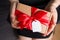 Valentines day gift with gift tag and bow closeup - woman holding in hands present
