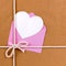 Valentines day gift with heart shape card or gift tag, brown paper package parcel background