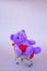 Valentines Day gift. Lilac Teddy Bear, bright plush toy with red heart in supermarket trolley