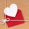 Valentines day gift with white heart shape card, red envelope, brown paper package parcel background
