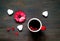 Valentines day greeting postcard. Flower and big red cup of coffee on wooden background.
