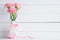 Valentines day and love concept. Pink carnation flower in vase with Wooden letters forming word LOVE written on white background