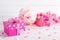 Valentines day and love concept. Pink gift box with handmade red heart and flowers on wooden block on white wooden background
