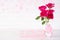 Valentines day and love concept. Pink roses in vase with wooden heart and with Wooden letters forming word LOVE written on white