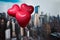 Valentines day in the New York city. man and woman hands holding three red balloons in form of heart over Manhattan and skyscraper
