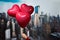 Valentines day in the New York city. woman hand holding three red balloons in form of heart over Manhattan and skyscrapers.