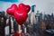 Valentines day in the New York city. woman hand holding three red balloons in form of heart over Manhattan and skyscrapers.