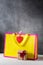 Valentines day present gift bag in bright colors pink and yellow with little wrapped present box