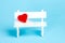 Valentines day red heart white bench blue background