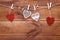 Valentines day romantic background, red and white handmade wood toy decorative hearts hanging on brown wooden table, happy holiday