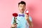 Valentines day. Romantic funny guy going to make wedding proposal, asking to marry him, holding red rose and looking at