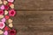 Valentines Day side border of hearts and roses against rustic wood