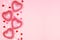 Valentines Day side border of pink and white heart decorations against a pink background with copy space