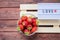 Valentines day, sweets and confectionery concept .word love made on light box and strawberry over wooden boards