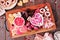 Valentines Day sweets and cookies, above view in a serving tray over wood