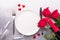 Valentines day table setting with bouquet of roses, red roses and champagne glasses on stone background. Top view. Valentine`s