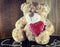 Valentines Day. Teddy Bear Loving cute with red hearts sitting alone.