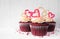 Valentines Day theme red velvet cupcakes with a white wood background