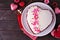 Valentines Day theme red velvet heart shaped cake over a dark wood background