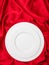 Valentines dinner concept. Top view of empty set of white plates on red satin background. Copy space
