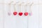 Valentineâ€™s Day. Sewed pillow hearts row border on red and white clothespins at rustic