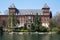 Valentino castle red bricks facade and Po river, clear blue sky in Piedmont, Turin, Italy