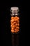 Valerian in a bottle on a black background, mirroring. Space for text.