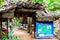 Vallee de Mai Nature Reserve entrance gate with thatched roof with dried palm tree leaves and map of a reserve..