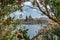 Valletta,capital of Malta.View through blooming trees of sea,small boat,town with church and houses with colorful doors and