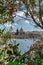 Valletta,capital of Malta.View through blooming trees of sea,small boat,town with church and houses with colorful doors and