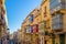 Valletta, Malta - Typical narrow street with colorful traditional windows and balconies and clear blue sky on a summer day