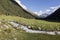 Valley of Altyn-Arashan in the late afternoon with a creek in the foreground in Kyrgyzstan