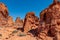 Valley of Fire - Woman at exterior entrance of windstone arch (fire cave) in Valley of Fire State Park, Mojave desert, Nevada, USA