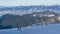Valley of hilghland mountain winter resort on bright sunny day. Panoramic wide view of downhill slopes