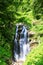 A valley with a waterfall in Mountains near the ski resort in tropical forest. Russian nature near Sochi, Caucasus