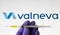 Valneva COVID-19 vaccine concept. Syringe and Valneva company logo on the blurred background screen. Stafford, United Kingdom,