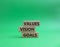 Values Vision Goals symbol. Concept words Values Vision Goals on wooden blocks. Beautiful green background. Business and Values