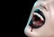 Vampire teeth with dripping blood, Woman`s black bloody lips close-up. Vampire girl fangs. Fashion Halloween art design