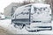 Van on a street covered with big snow layer.
