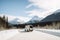 van, surrounded by snow and mountains, on scenic winter road trip