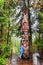 Vancouver tourist woman posing by totem pole, British Columbia, Canada. Asian girl visiting famous popular tourism attraction in