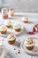 Vanilla cupcakes decorated with white frosting and dried strawberry on gray table. Side view, close up. Cookbook recipe, menu,