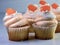 Vanilla cupcakes with orange and white swirled frosting and an orange candy gumdrop on top, festive and delicious for a