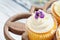 Vanilla Cupcakes with Sugar Coated Violet Flowers on a Cake Stand